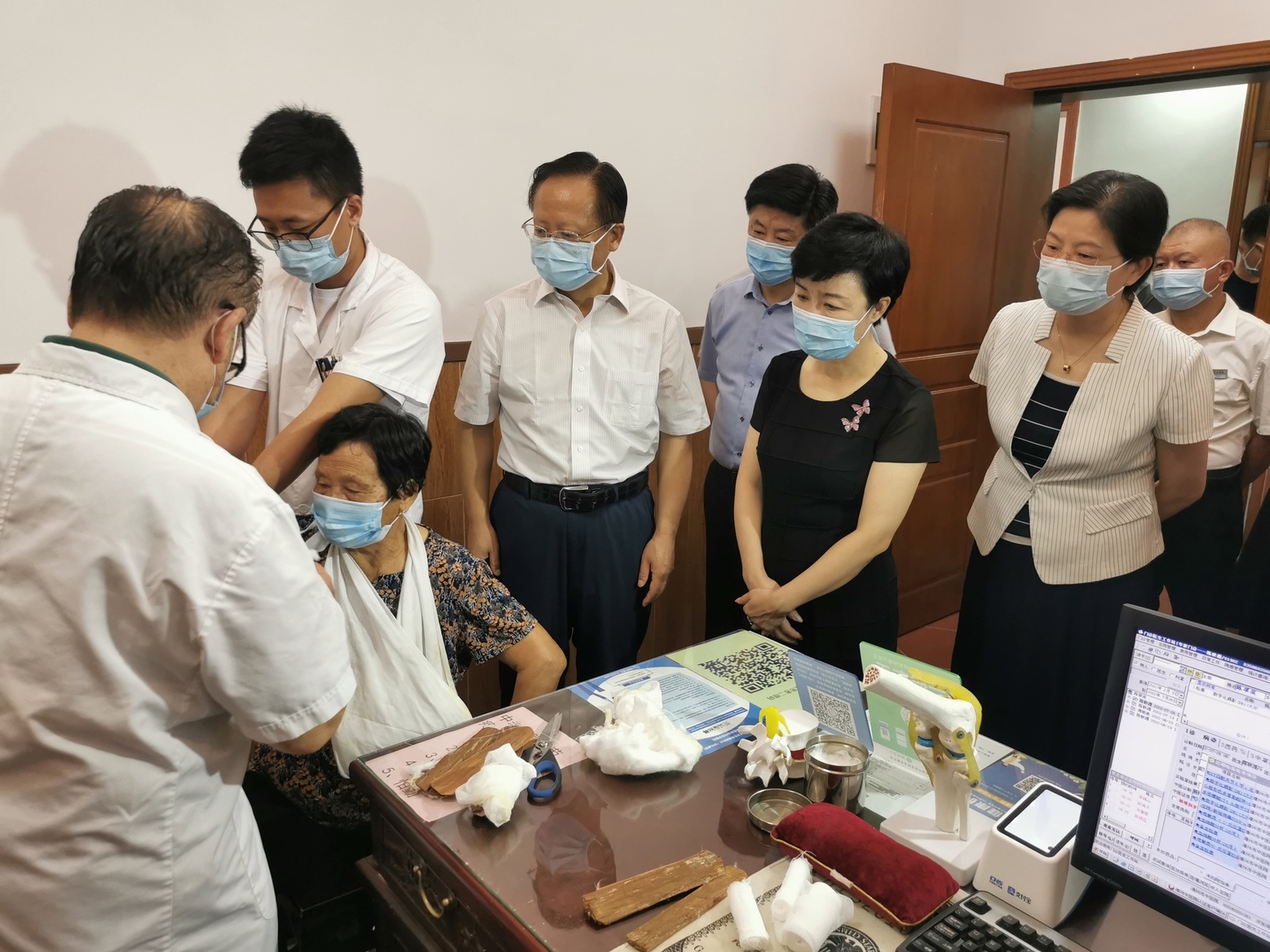 秦怀金副局长驻足观看骨伤名医陈联源行章宝春整复手法小夹板外固定术.jpg